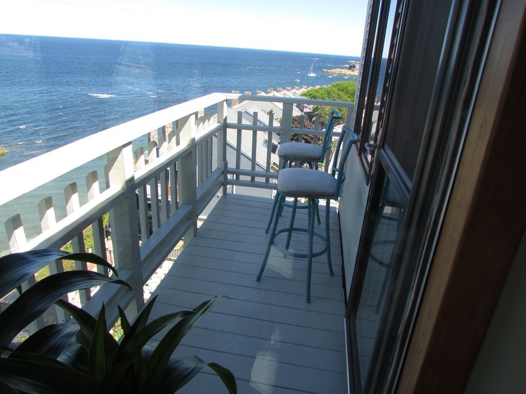 59 Oceanside Drive, Unit 59 Hull, MA 02045 - Photo 19 of 29 a view of a balcony with chairs and wooden floor