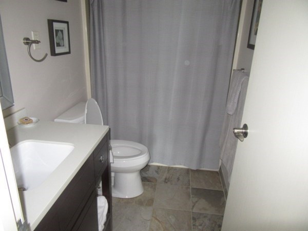 59 Oceanside Drive, Unit 59 Hull, MA 02045 - Photo 20 of 29 a bathroom with a sink a toilet and shower curtain