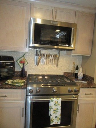 59 Oceanside Drive, Unit 59 Hull, MA 02045 - Photo 7 of 29 a stove top oven sitting inside of a kitchen