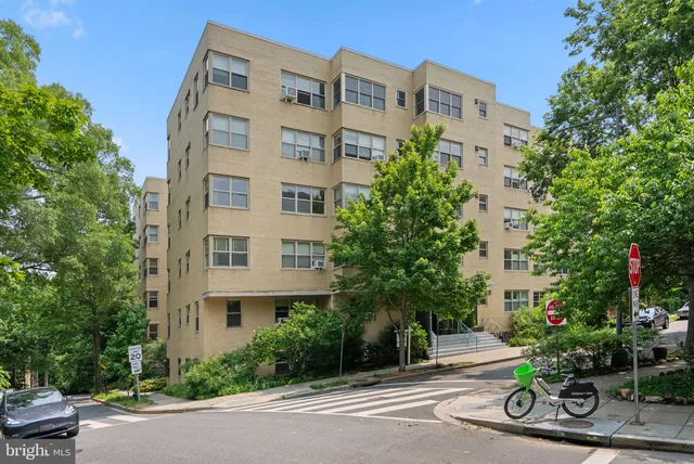 a view of a tall building sitting in the middle of a street