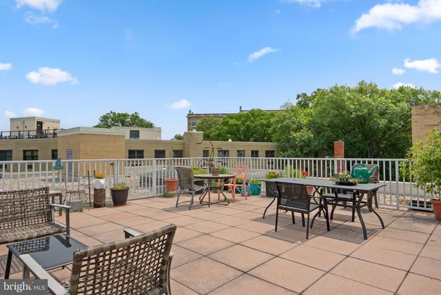 a patio with glass top table and chairs