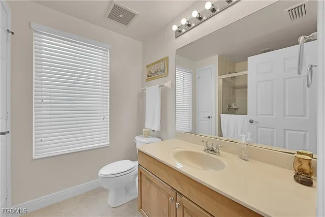 a bathroom with a granite countertop sink toilet a large mirror and a tub