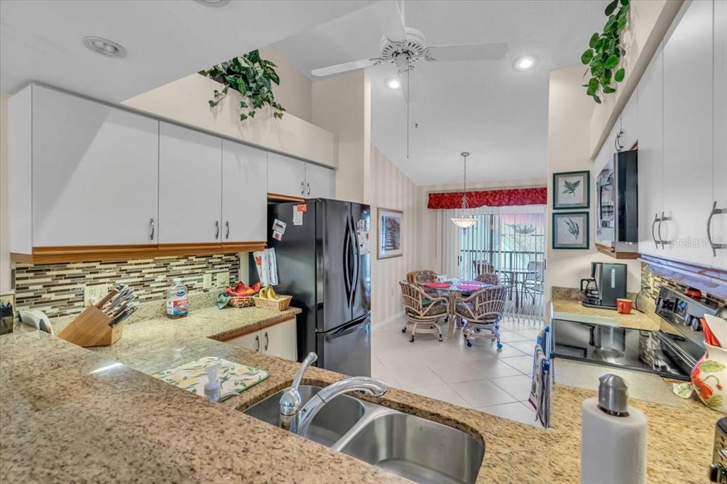 6713 Stone River Road, Unit 206 Bradenton, FL 34203 - Photo 18 of 58 a kitchen with refrigerator and cars