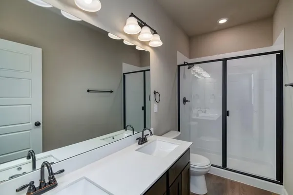 a bathroom with a sink a toilet and a large mirror