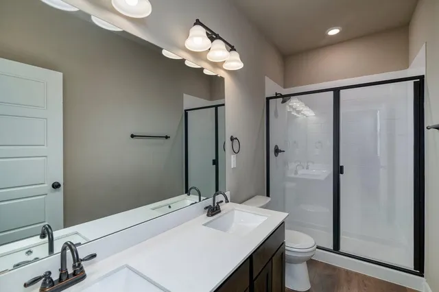 a bathroom with a sink a toilet and a large mirror