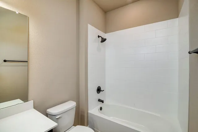 a white toilet sitting next to a bath tub