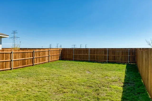 a view of a yard with wooden fence