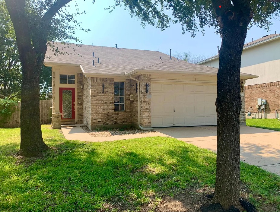 2120 Jester Farms Road Round Rock, TX 78664 - Photo 1 of 28 A well-maintained facade features a vibrant red entry door, framed by mature trees and a neatly manicured lawn.