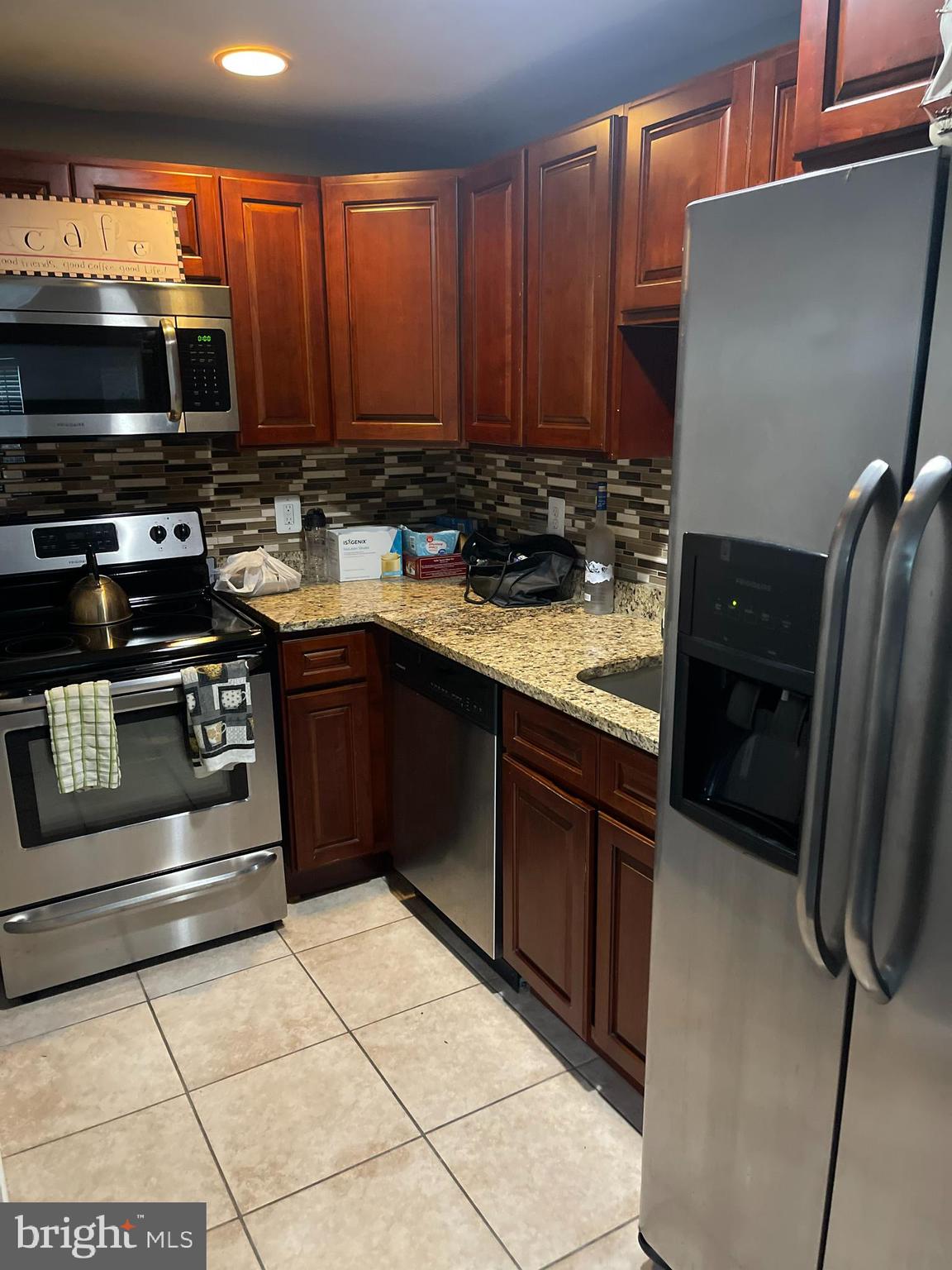 a kitchen with stainless steel appliances granite countertop a stove refrigerator and microwave