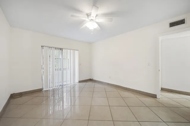 an empty room with a ceiling fan and carpet