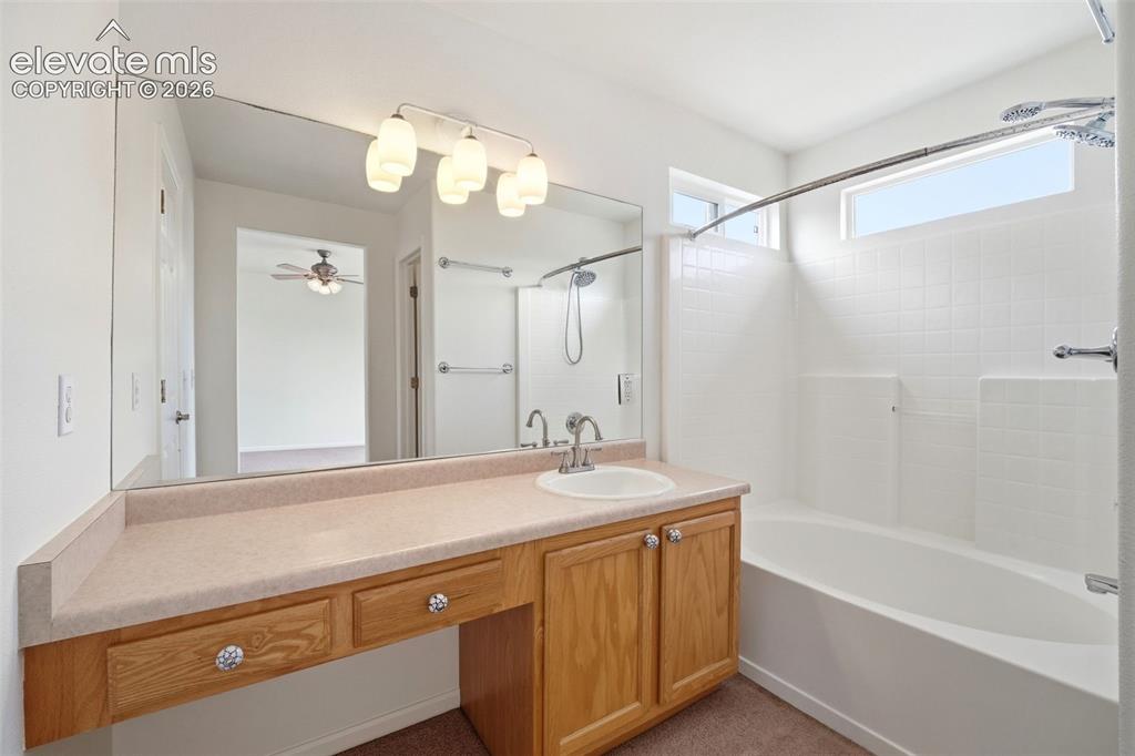 7904 Coffee Road Peyton, CO 80831 - Photo 24 of 48 Bathroom featuring a vanity with wood cabinetry, an integrated sink, and a large mirror