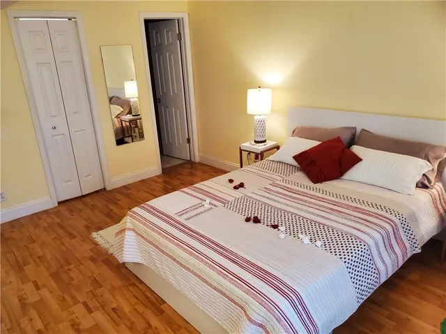 a bedroom with a bed and wooden floor