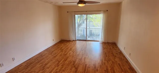 a view of a room with wooden floor and a window