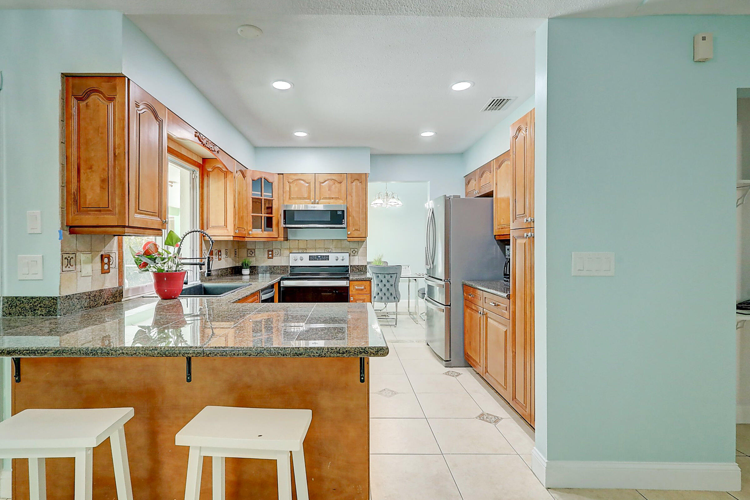 238 Southwest Grove Avenue Port St. Lucie, FL 34983 - Photo 11 of 47 a kitchen with stainless steel appliances granite countertop a refrigerator a stove top oven and a sink with granite countertops