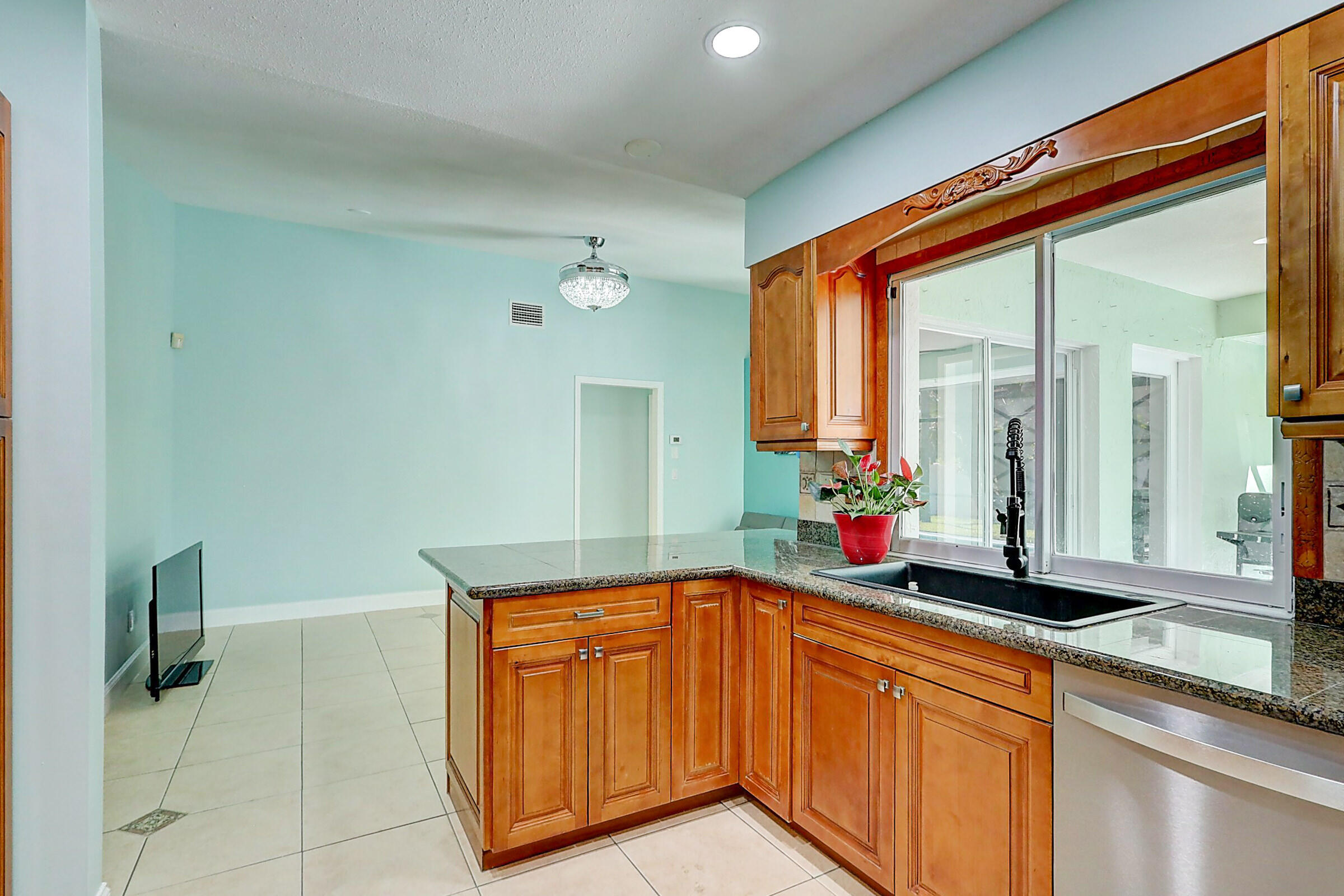 238 Southwest Grove Avenue Port St. Lucie, FL 34983 - Photo 15 of 47 a kitchen with stainless steel appliances granite countertop a sink and a wooden cabinets