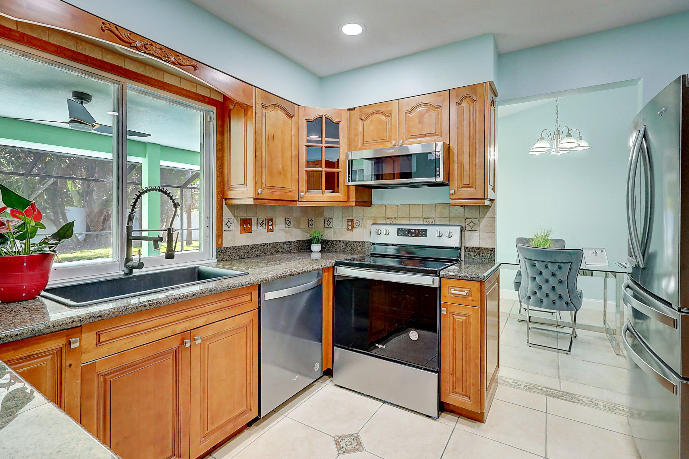 238 Southwest Grove Avenue Port St. Lucie, FL 34983 - Photo 16 of 47 a kitchen with stainless steel appliances granite countertop a stove a sink and a microwave