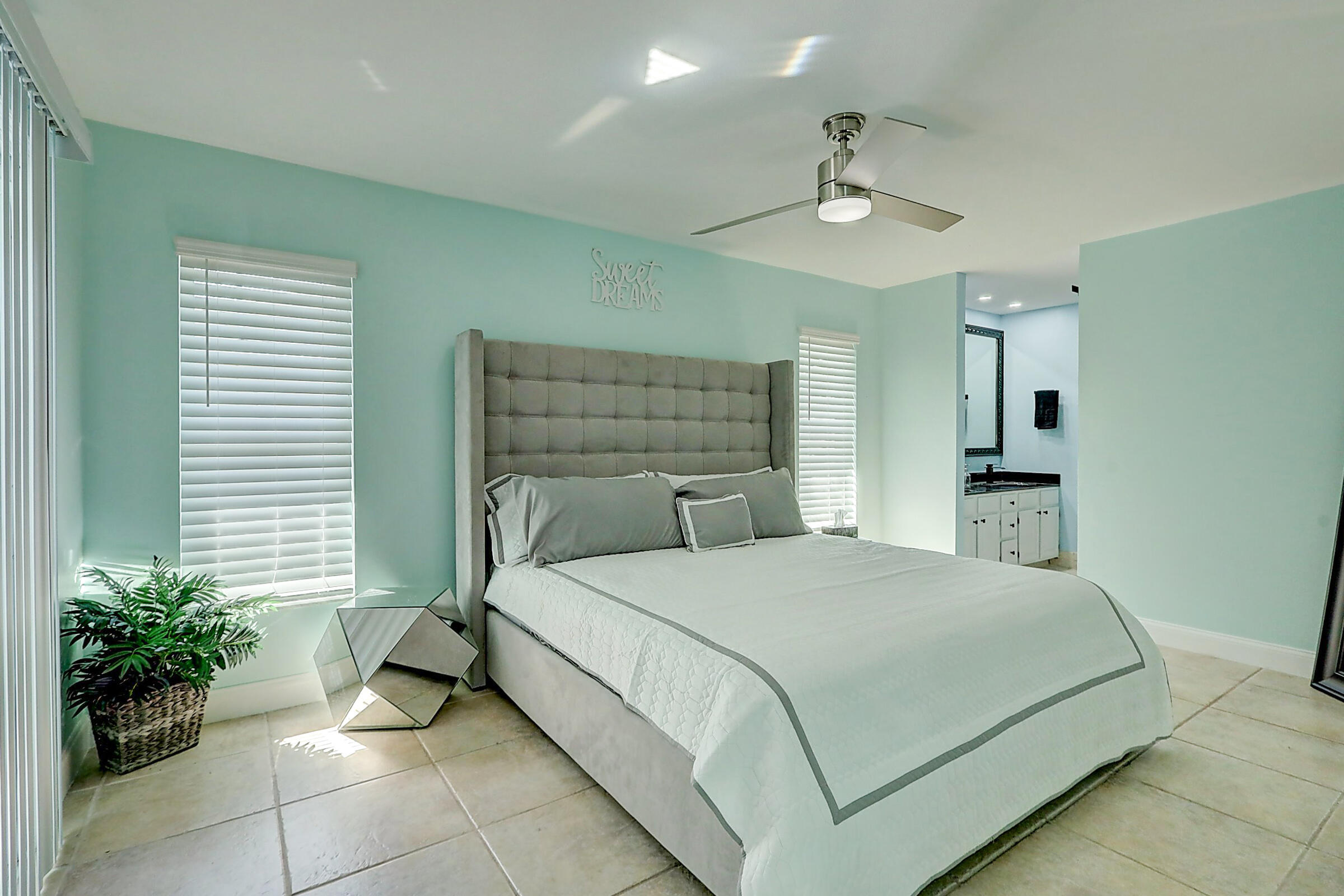 238 Southwest Grove Avenue Port St. Lucie, FL 34983 - Photo 17 of 47 a bedroom with a bed and a chandelier