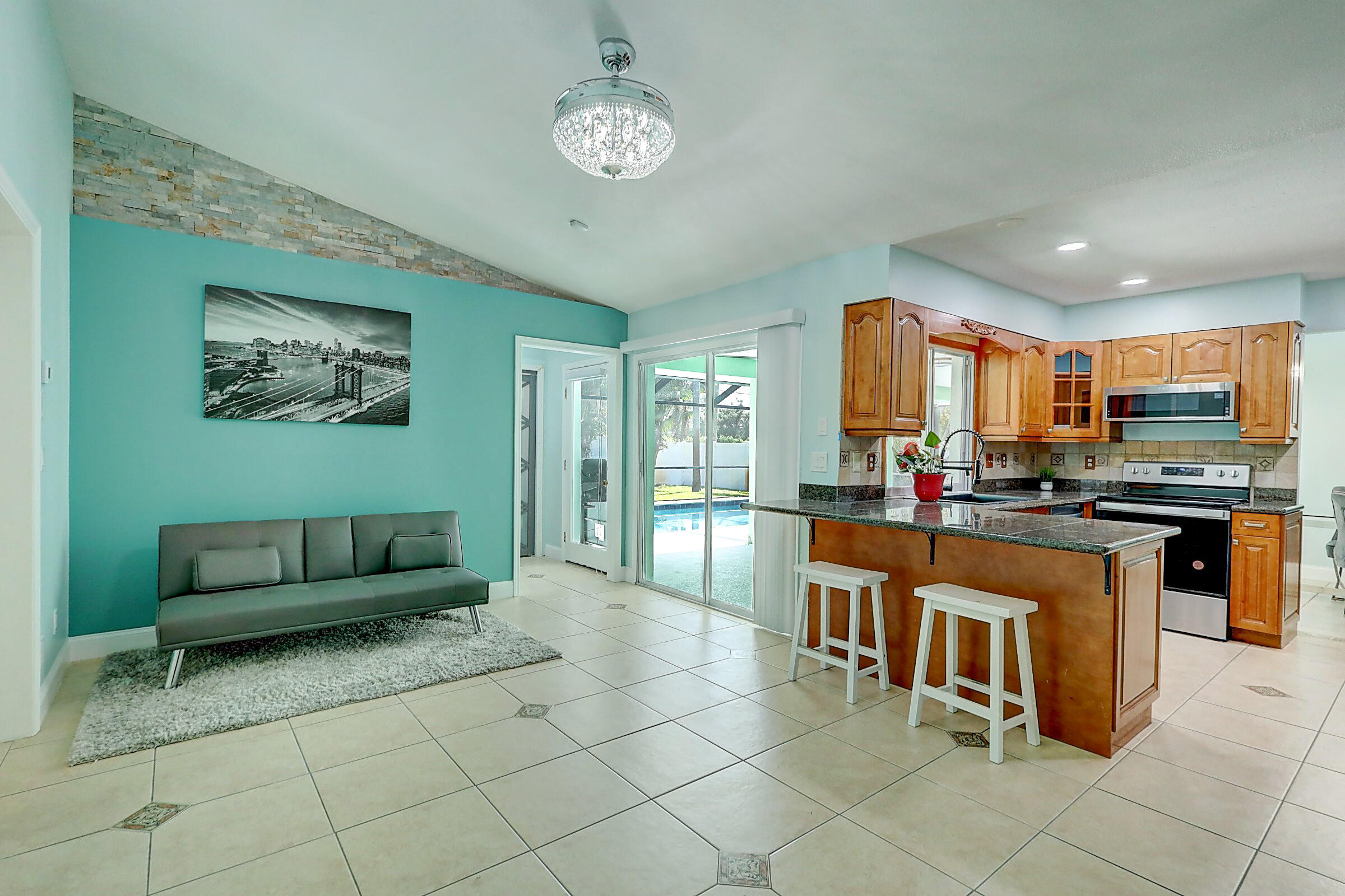 238 Southwest Grove Avenue Port St. Lucie, FL 34983 - Photo 25 of 47 a kitchen with stainless steel appliances kitchen island granite countertop a refrigerator a stove a sink and a dining table with the view