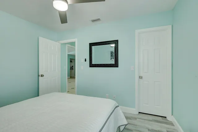 a bedroom with two beds and ceiling fan