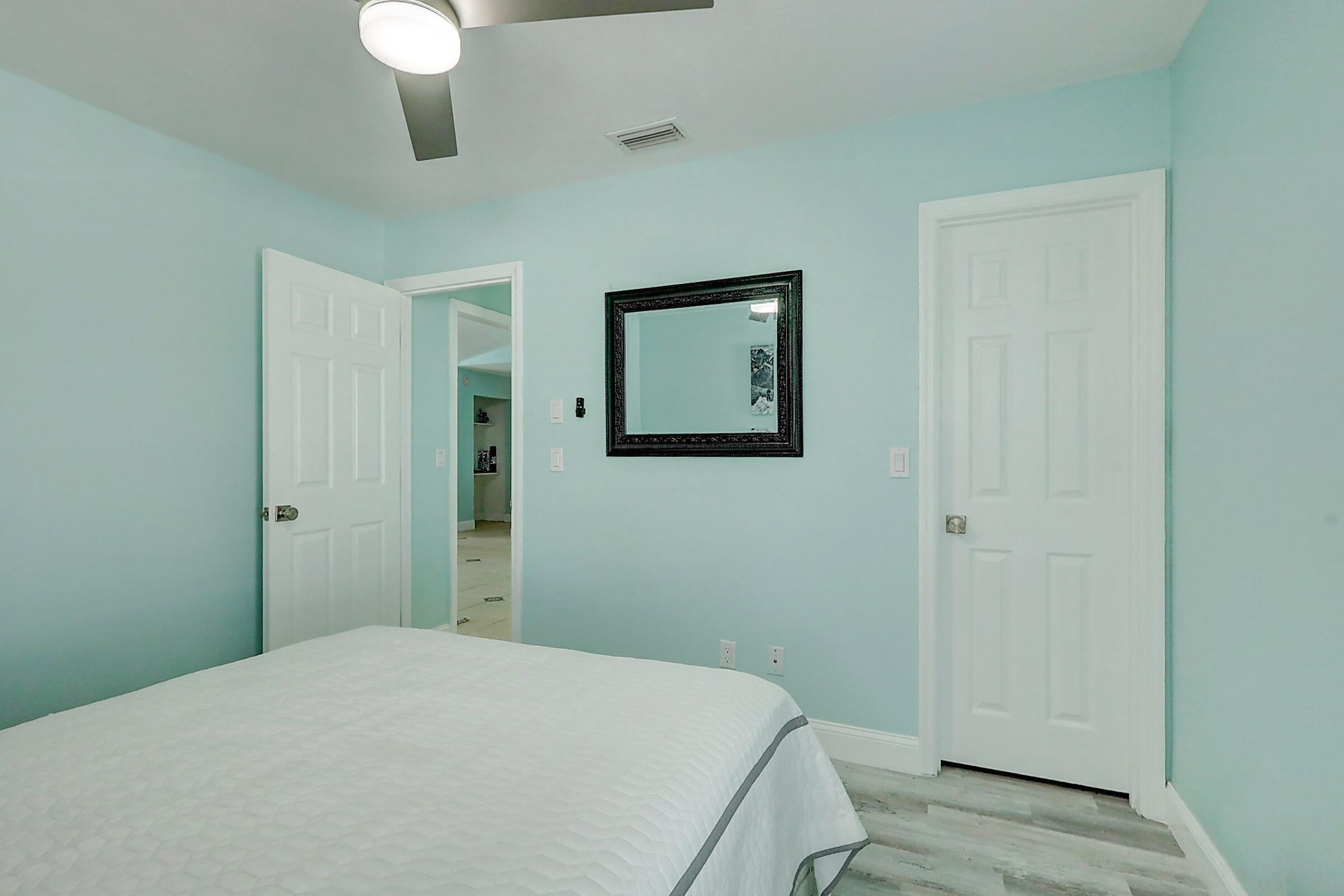 238 Southwest Grove Avenue Port St. Lucie, FL 34983 - Photo 29 of 47 a bedroom with a bed and a chandelier