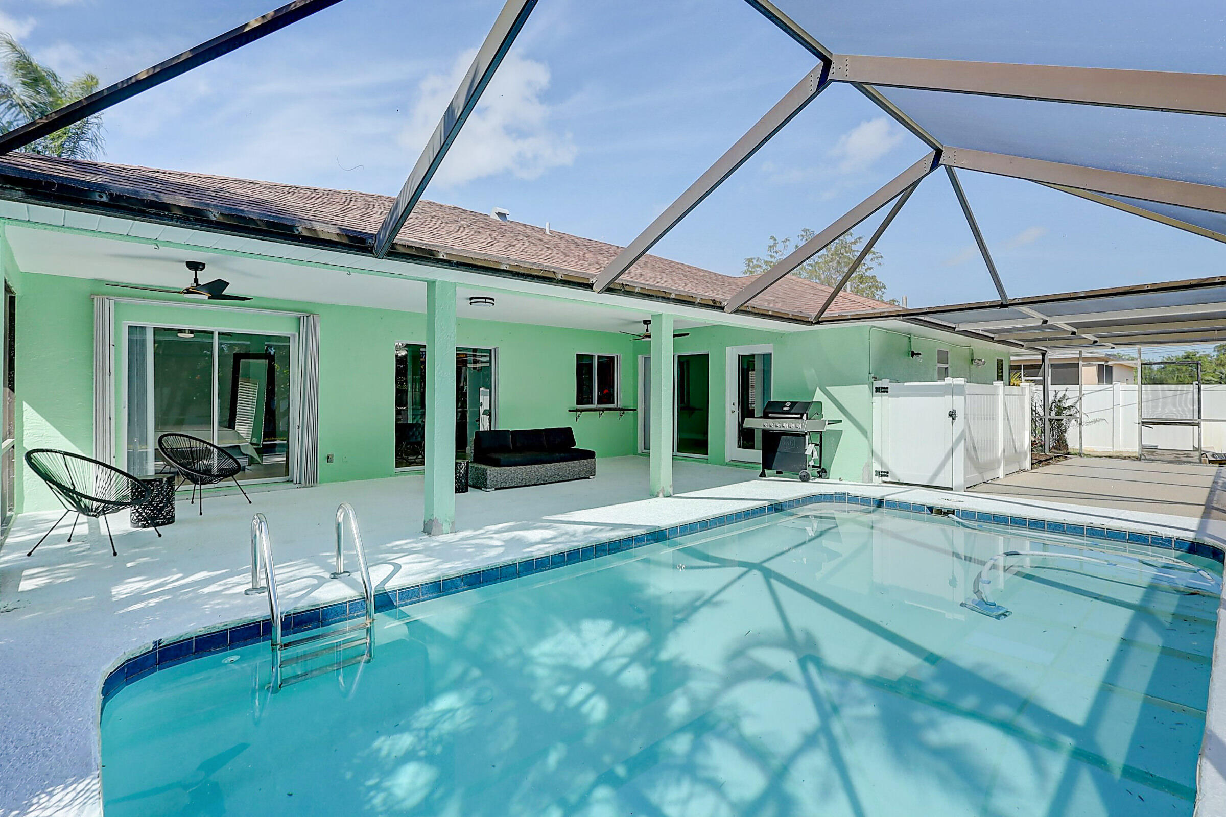 238 Southwest Grove Avenue Port St. Lucie, FL 34983 - Photo 38 of 47 a view of a patio with table and chairs under an umbrella