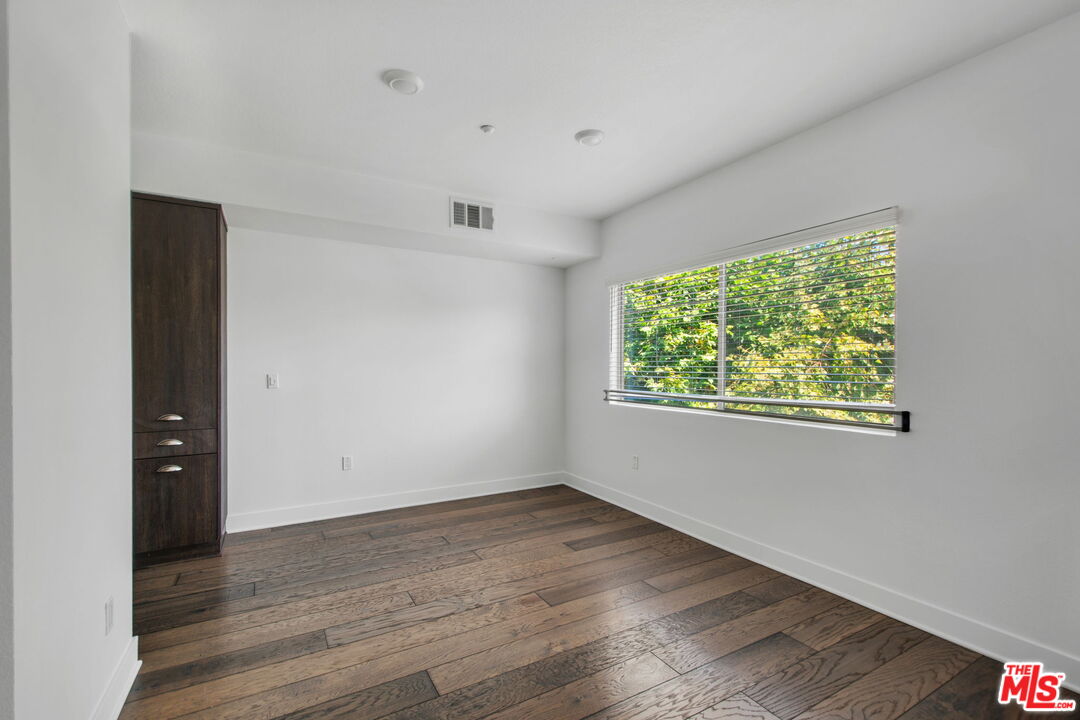 2974 Ripple Place, Unit 203 Los Angeles, CA 90039 - Photo 13 of 29 an empty room with wooden floor and windows