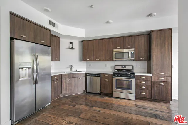 a large kitchen with stainless steel appliances granite countertop a stove a sink and a microwave