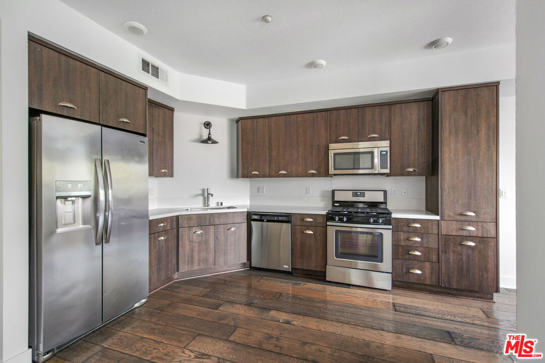 2974 Ripple Place, Unit 203 Los Angeles, CA 90039 - Photo 14 of 29 a kitchen with stainless steel appliances granite countertop a refrigerator stove and sink