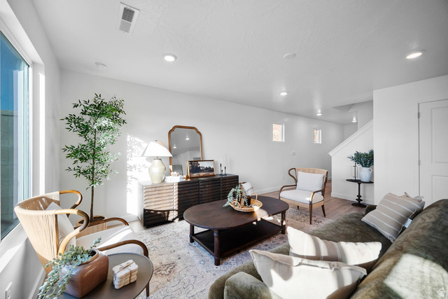 2123 Wolverine Way, Unit 2437 Washington, UT 84780 - Photo 22 of 40 Bright living area featuring expansive windows, recessed lighting, white walls, wood-finish flooring, and a staircase with white balusters