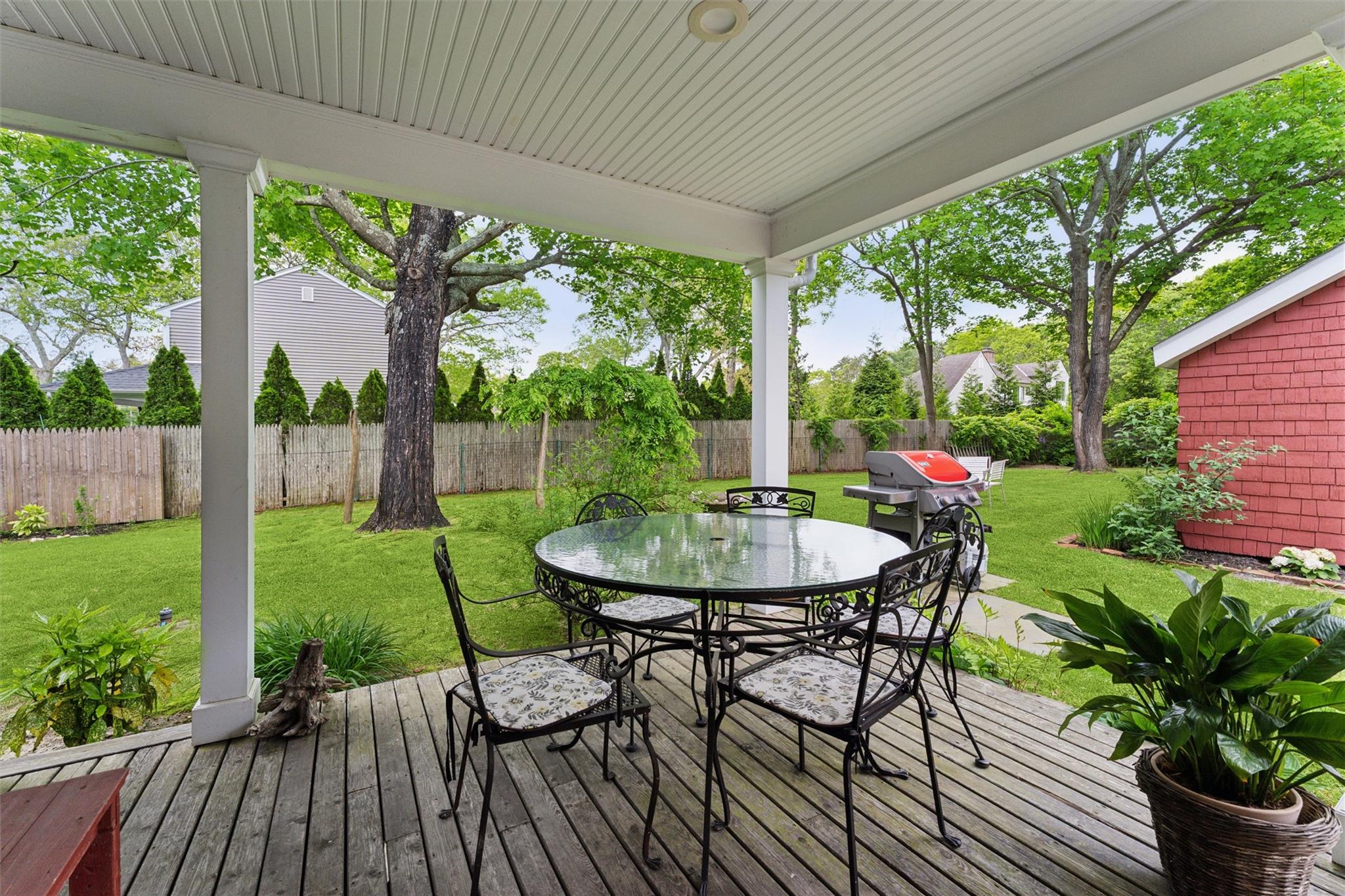 21 Summit Boulevard Westhampton, NY 11977 - Photo 22 of 28 a view of a table and chairs in patio with wooden fence