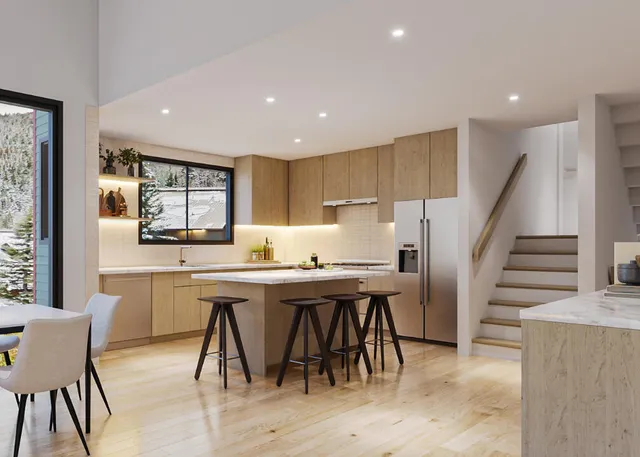 a kitchen with stainless steel appliances kitchen island granite countertop a table chairs sink and wooden cabinets