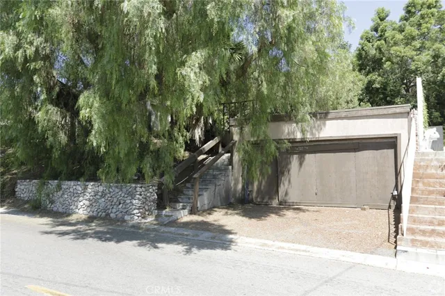 a view of a entrance gate of the house and trees
