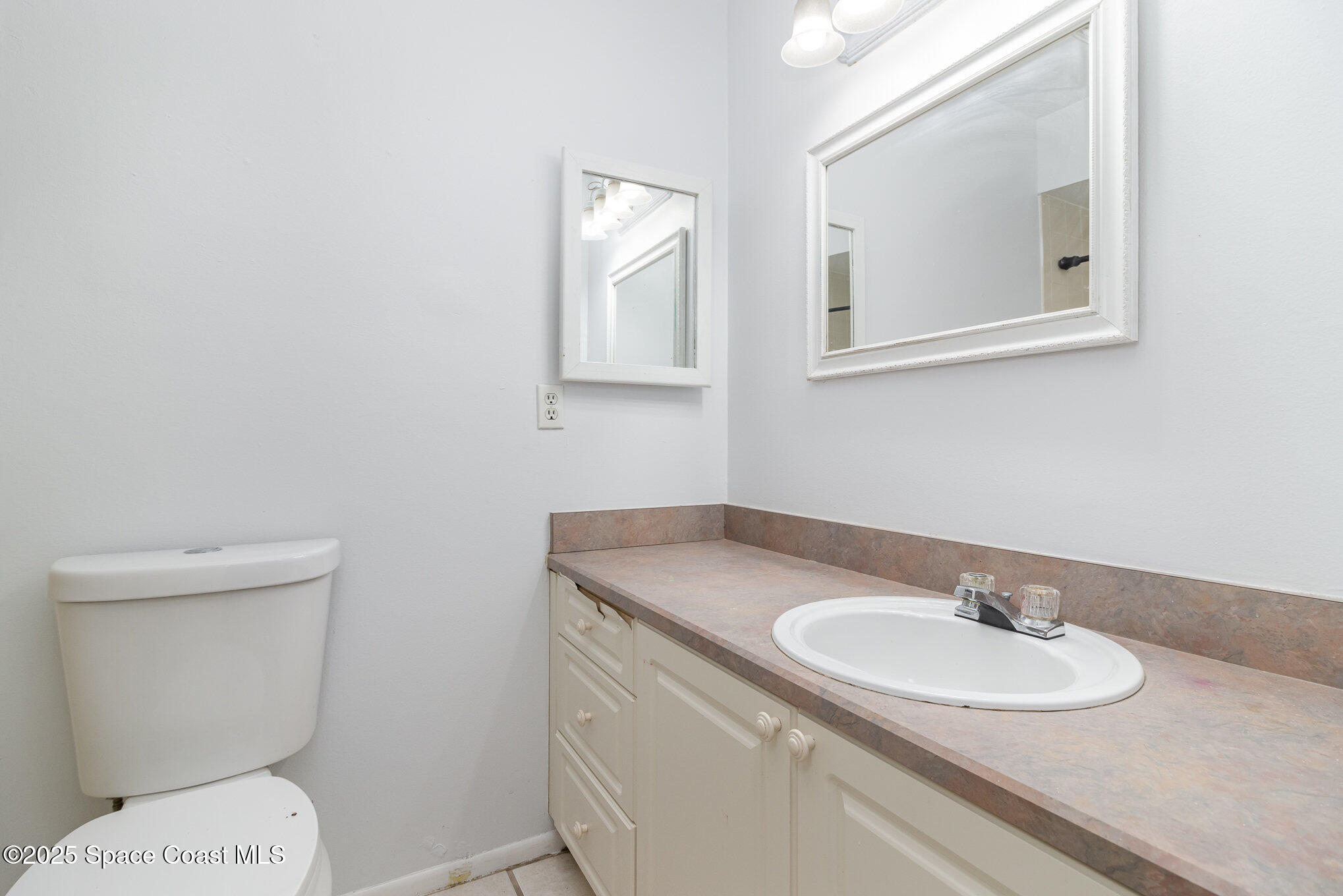 7413 Ester Road Cocoa, FL 32927 - Photo 13 of 30 a bathroom with a granite countertop toilet sink and mirror