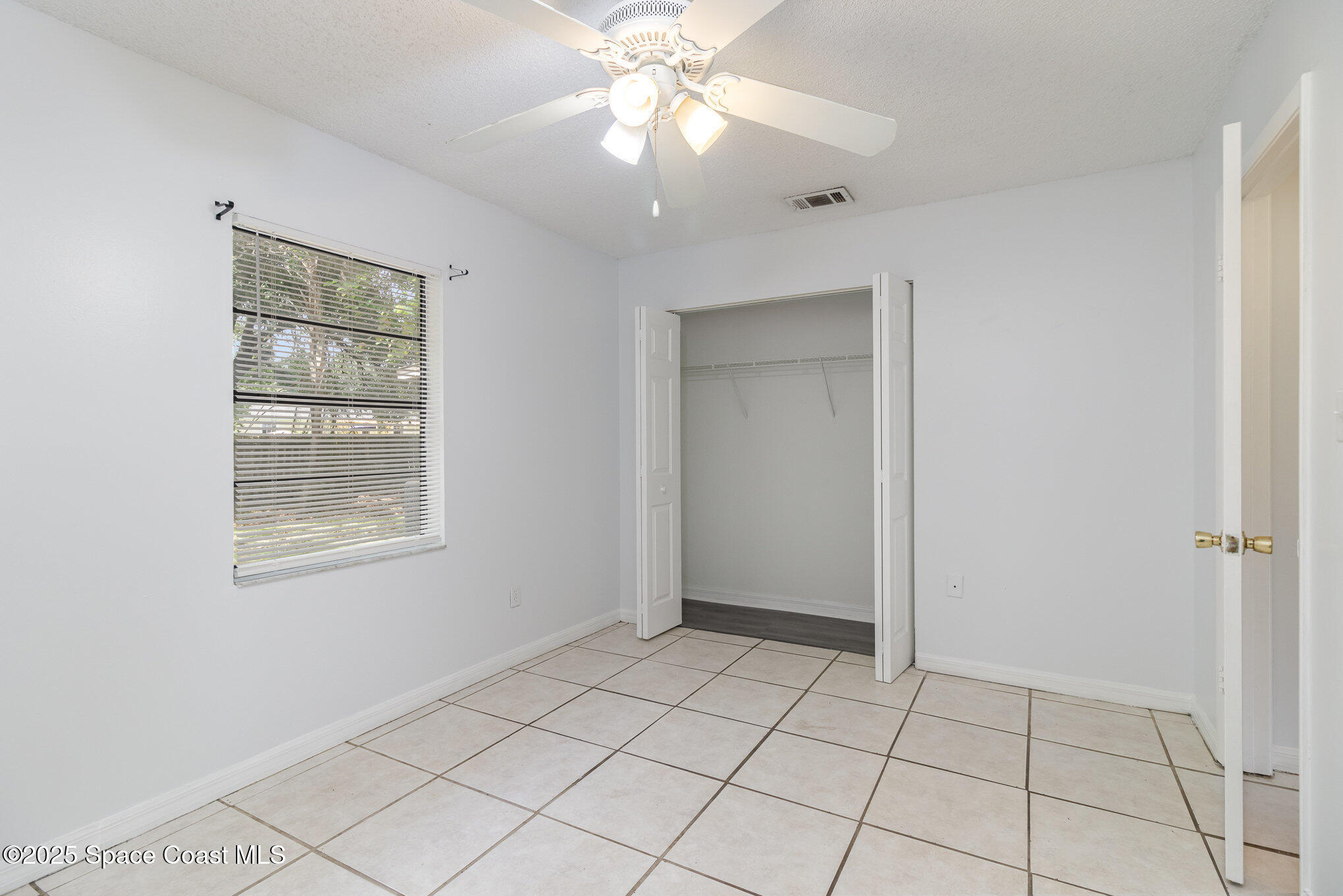 7413 Ester Road Cocoa, FL 32927 - Photo 18 of 30 a view of an empty room with window and chandelier fan