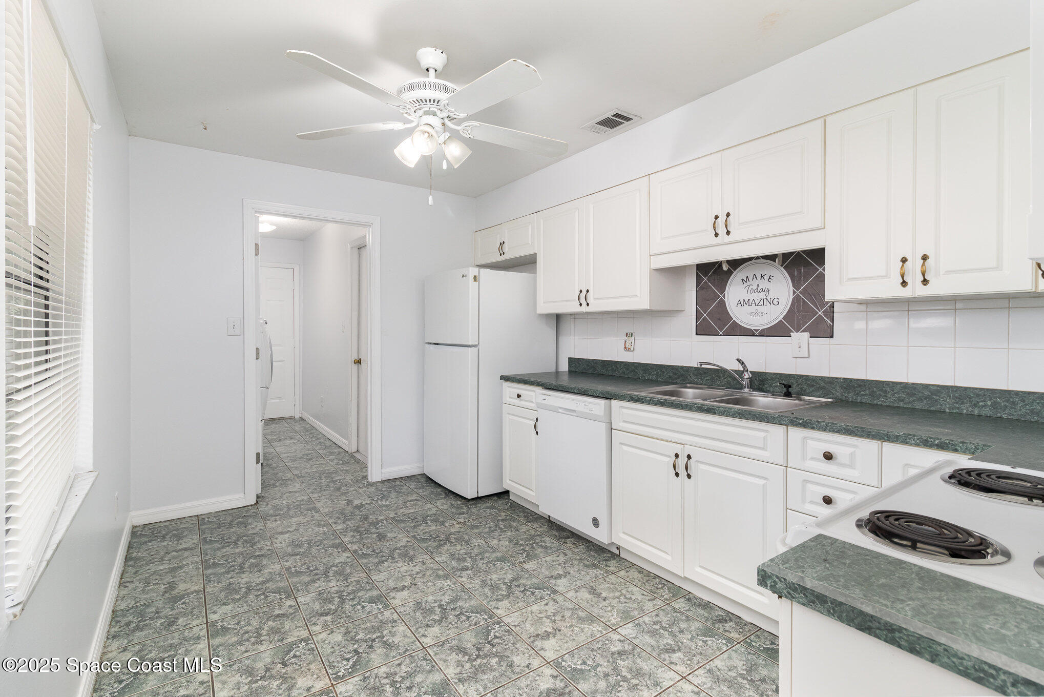 7413 Ester Road Cocoa, FL 32927 - Photo 7 of 30 a kitchen with granite countertop a sink cabinets and window