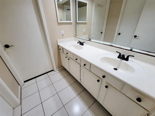a bathroom with a double vanity sink and mirror