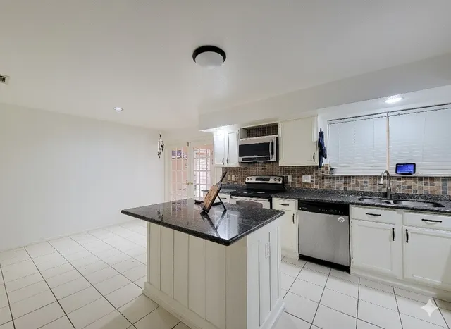 a kitchen with stainless steel appliances granite countertop a sink stove and cabinets