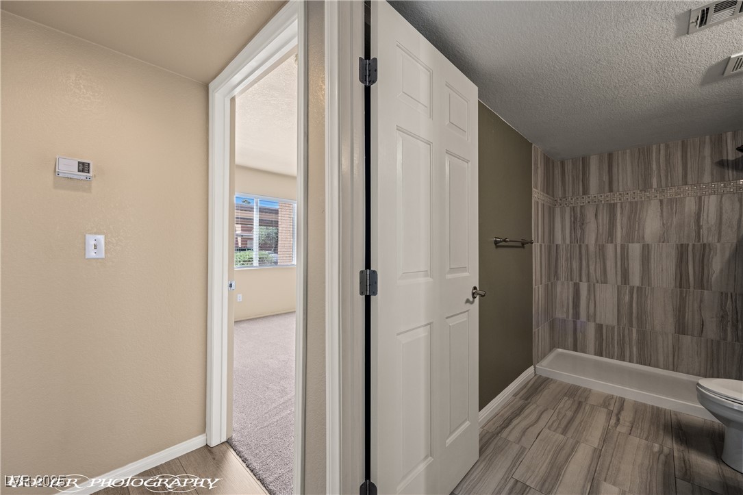 334 Colleen Court, Unit D Mesquite, NV 89027 - Photo 12 of 61 Bathroom featuring a tile shower and a textured ceiling