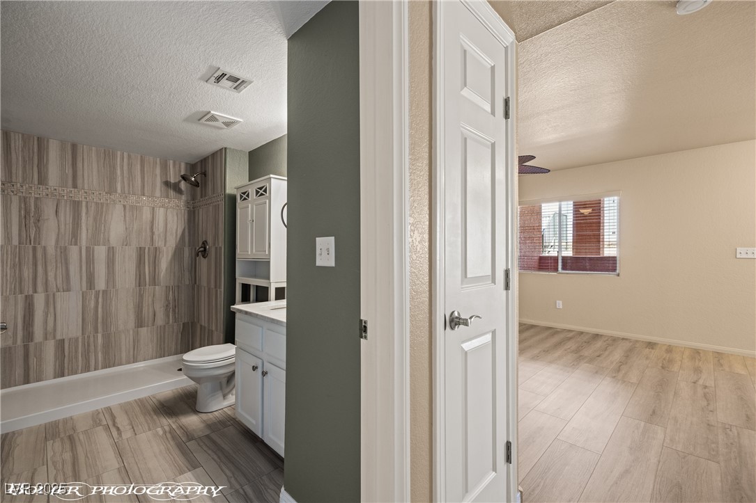 334 Colleen Court, Unit D Mesquite, NV 89027 - Photo 17 of 61 Full bath featuring a shower stall, light wood finished floors, vanity, and a textured ceiling
