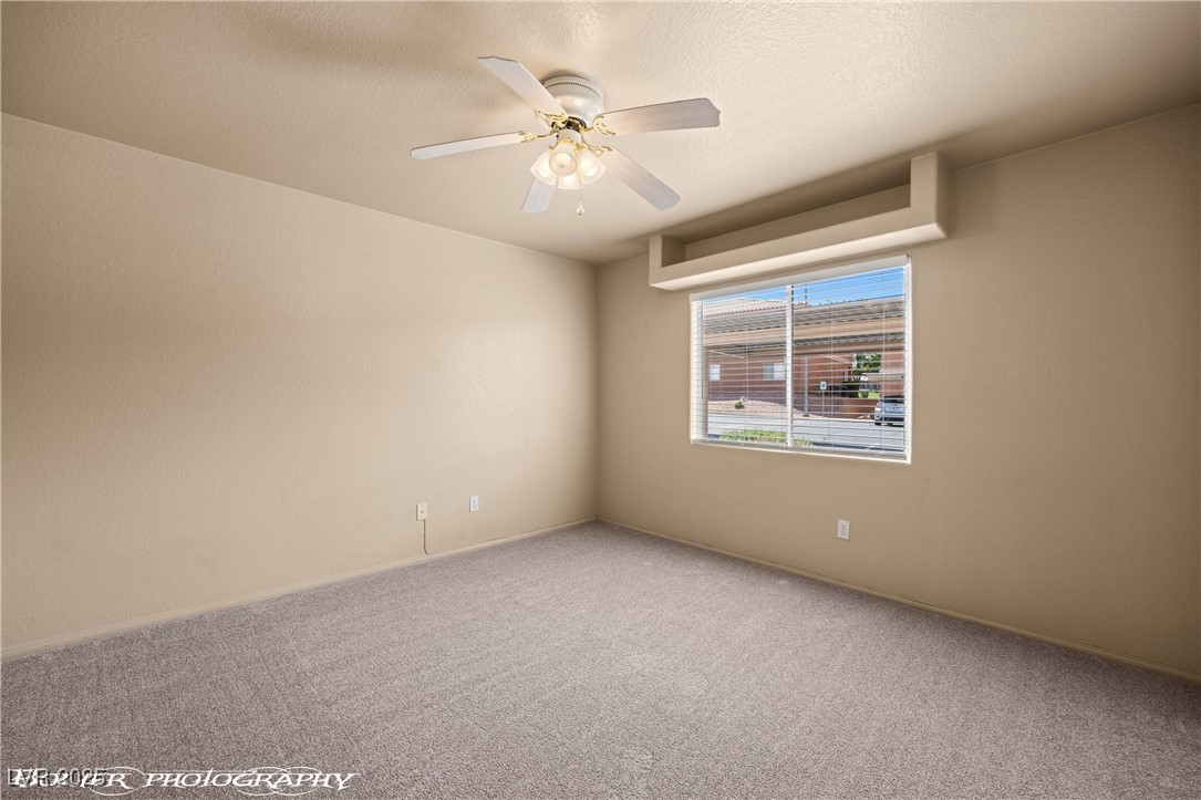 334 Colleen Court, Unit D Mesquite, NV 89027 - Photo 20 of 61 Carpeted spare room featuring ceiling fan and a textured ceiling