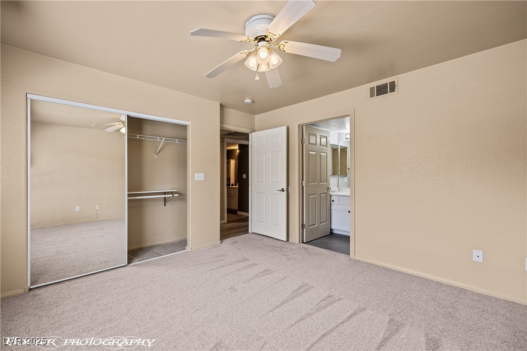 334 Colleen Court, Unit D Mesquite, NV 89027 - Photo 21 of 61 Unfurnished bedroom featuring carpet, a ceiling fan, and a closet