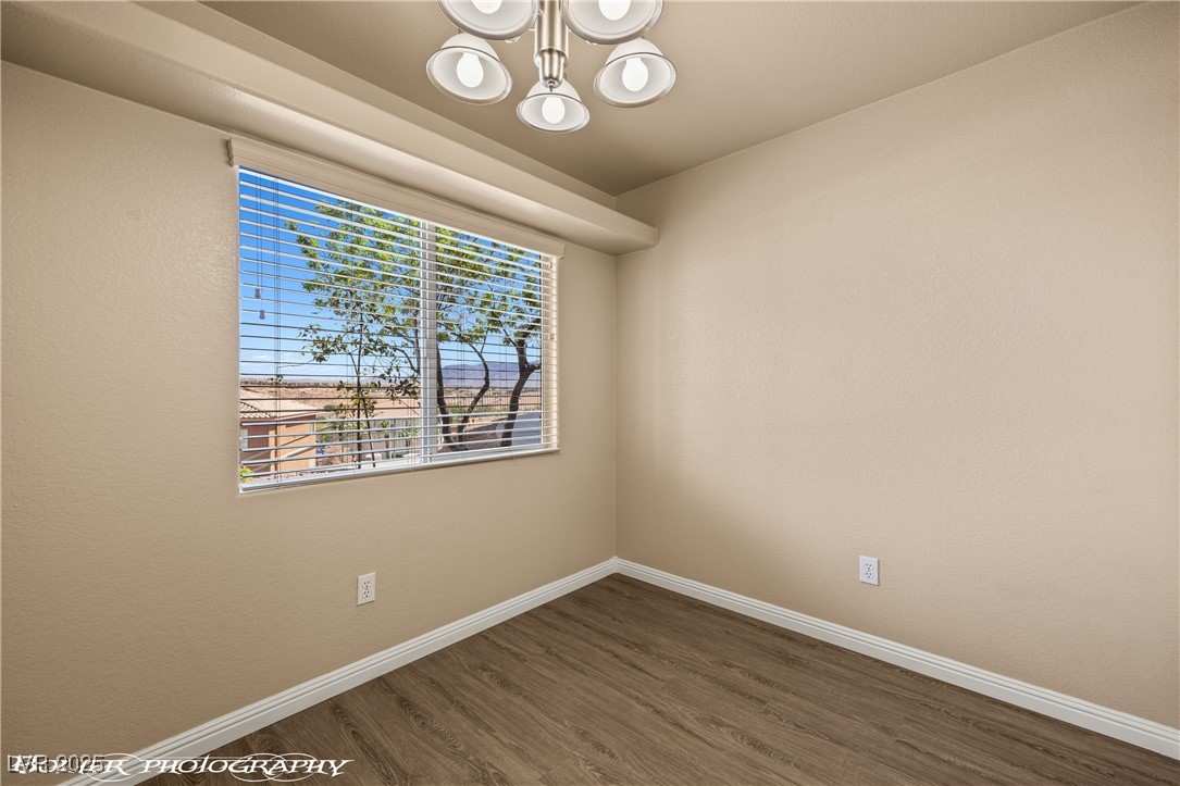 334 Colleen Court, Unit D Mesquite, NV 89027 - Photo 4 of 61 Unfurnished room featuring wood finished floors and a chandelier
