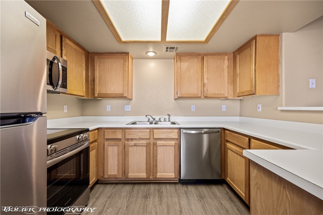 334 Colleen Court, Unit D Mesquite, NV 89027 - Photo 7 of 61 Kitchen featuring stainless steel appliances, light countertops, and light wood finished floors