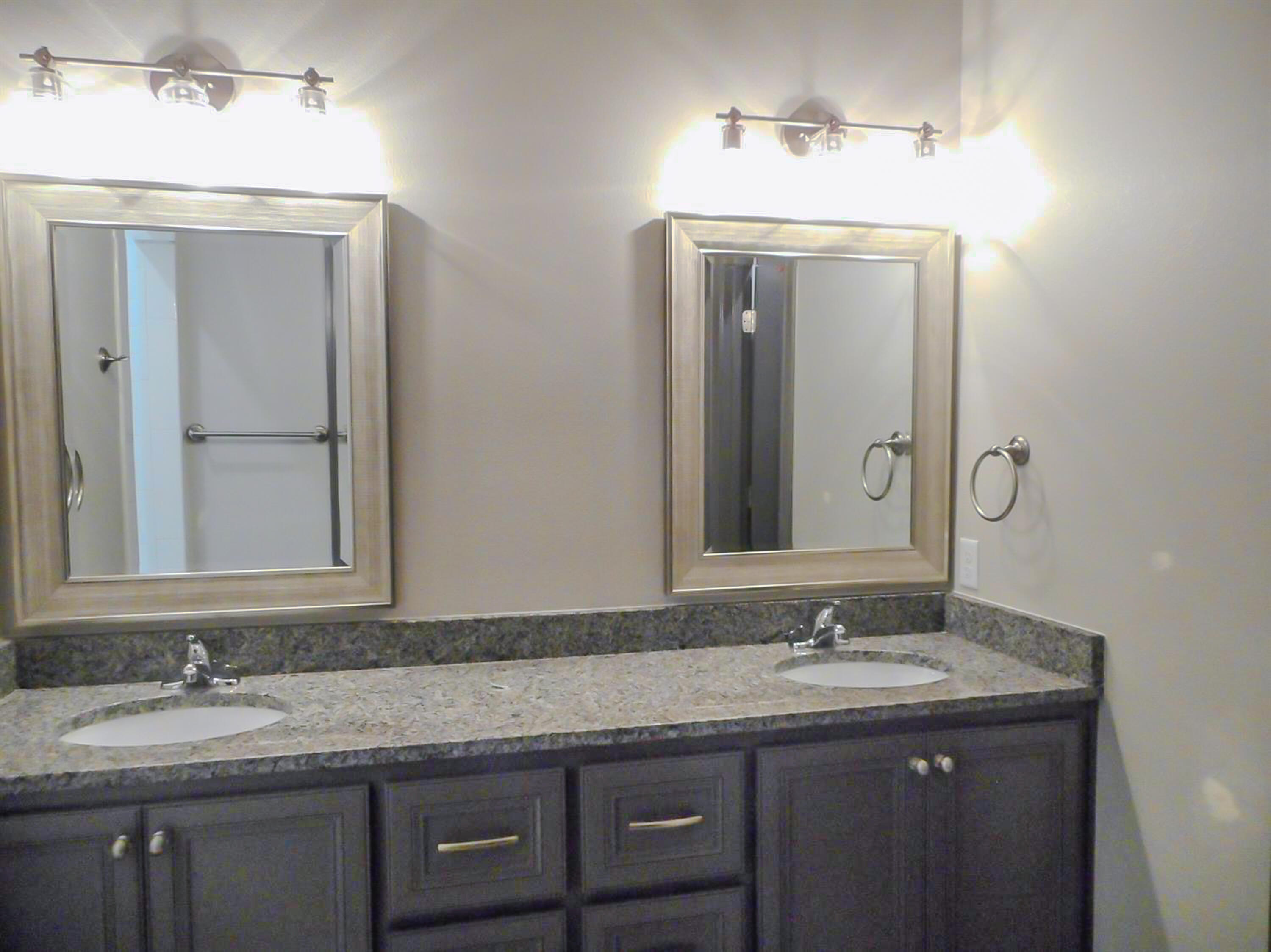 2026 102nd Street Lubbock, TX 79423 - Photo 12 of 16 a bathroom with a granite countertop sink a large mirror and a