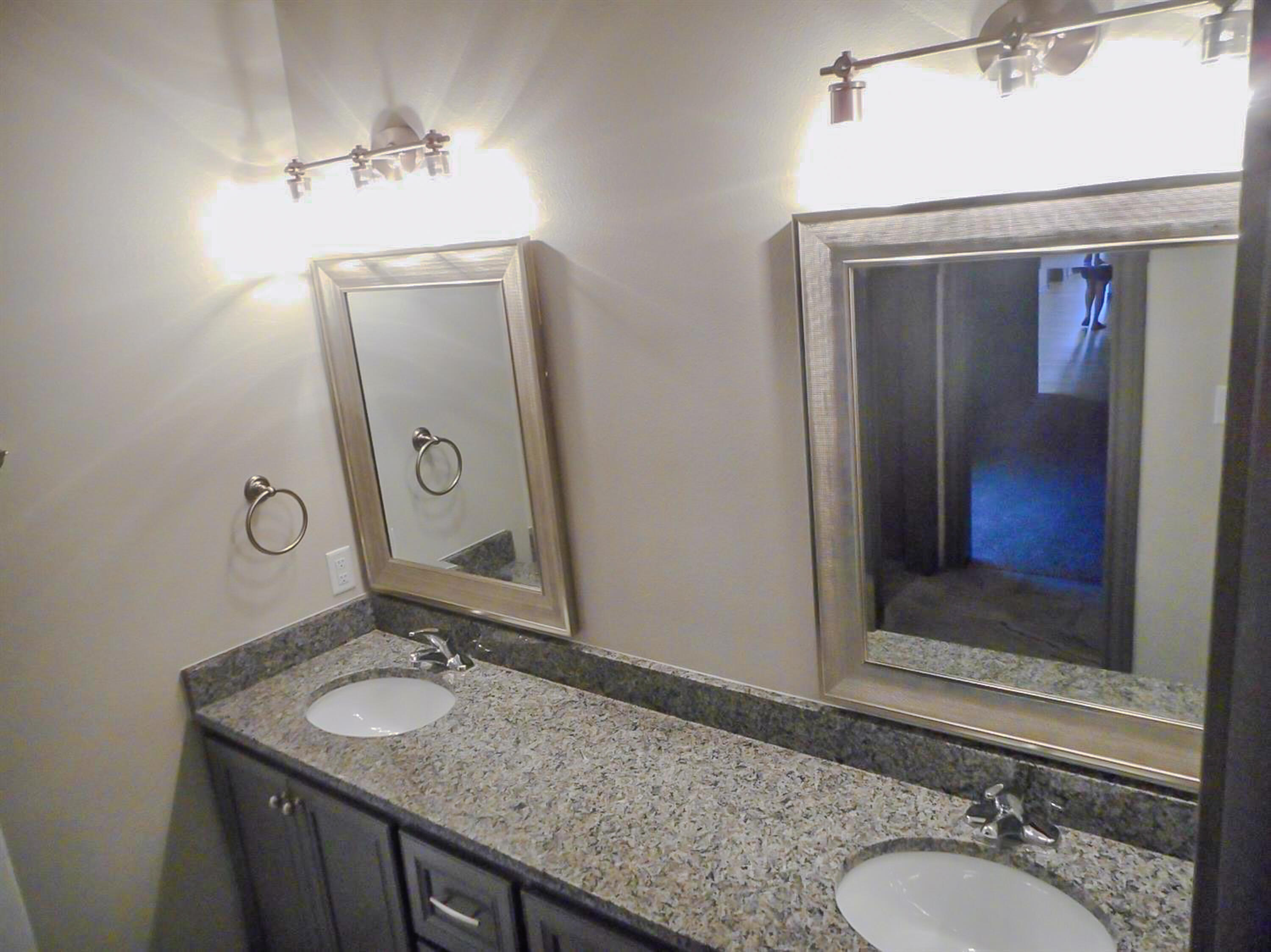 2026 102nd Street Lubbock, TX 79423 - Photo 13 of 16 a bathroom with a granite countertop sink and a mirror