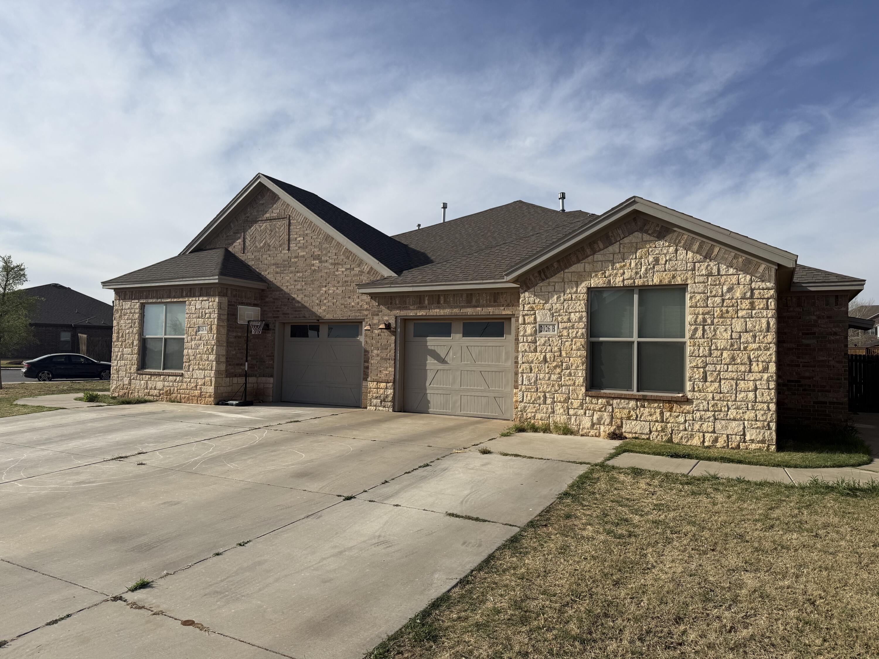 2026 102nd Street Lubbock, TX 79423 - Photo 2 of 16 a front view of a house with a yard and garage