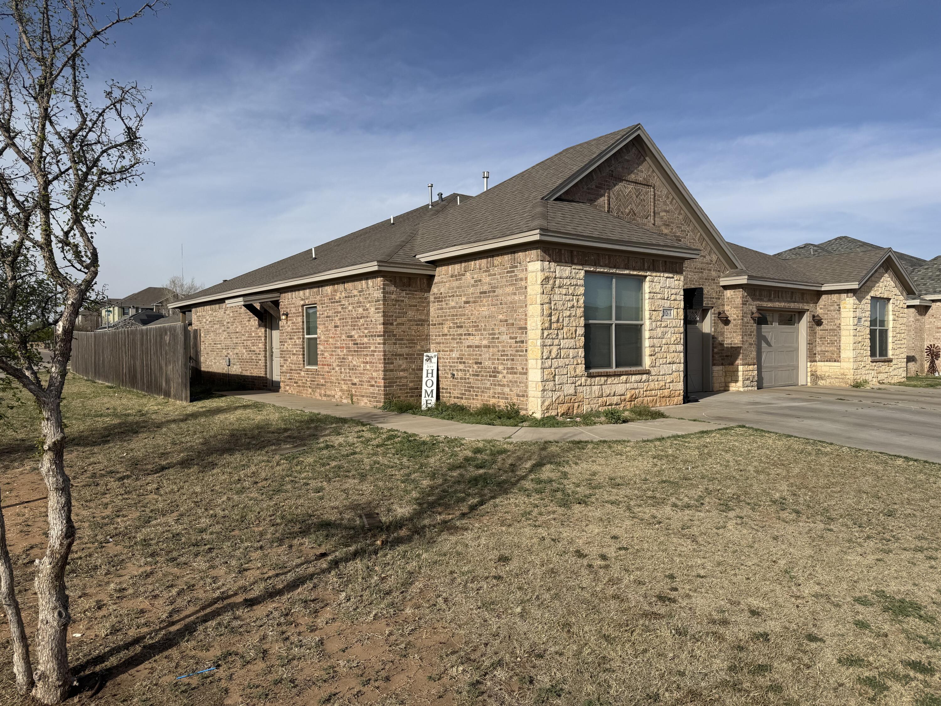 2026 102nd Street Lubbock, TX 79423 - Photo 4 of 16 a front view of a house with a yard