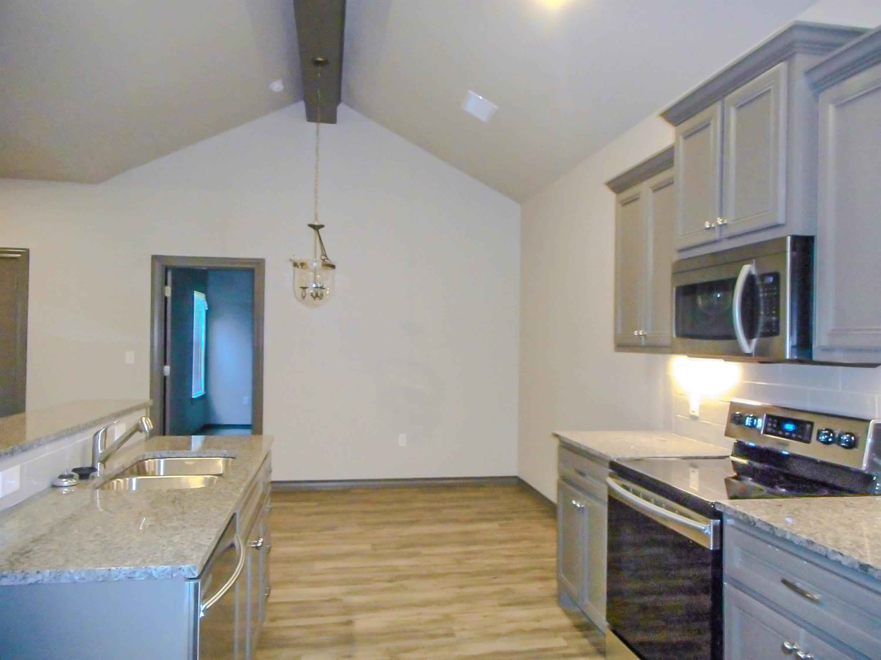 2026 102nd Street Lubbock, TX 79423 - Photo 7 of 16 a kitchen with stainless steel appliances granite countertop a sink and a stove
