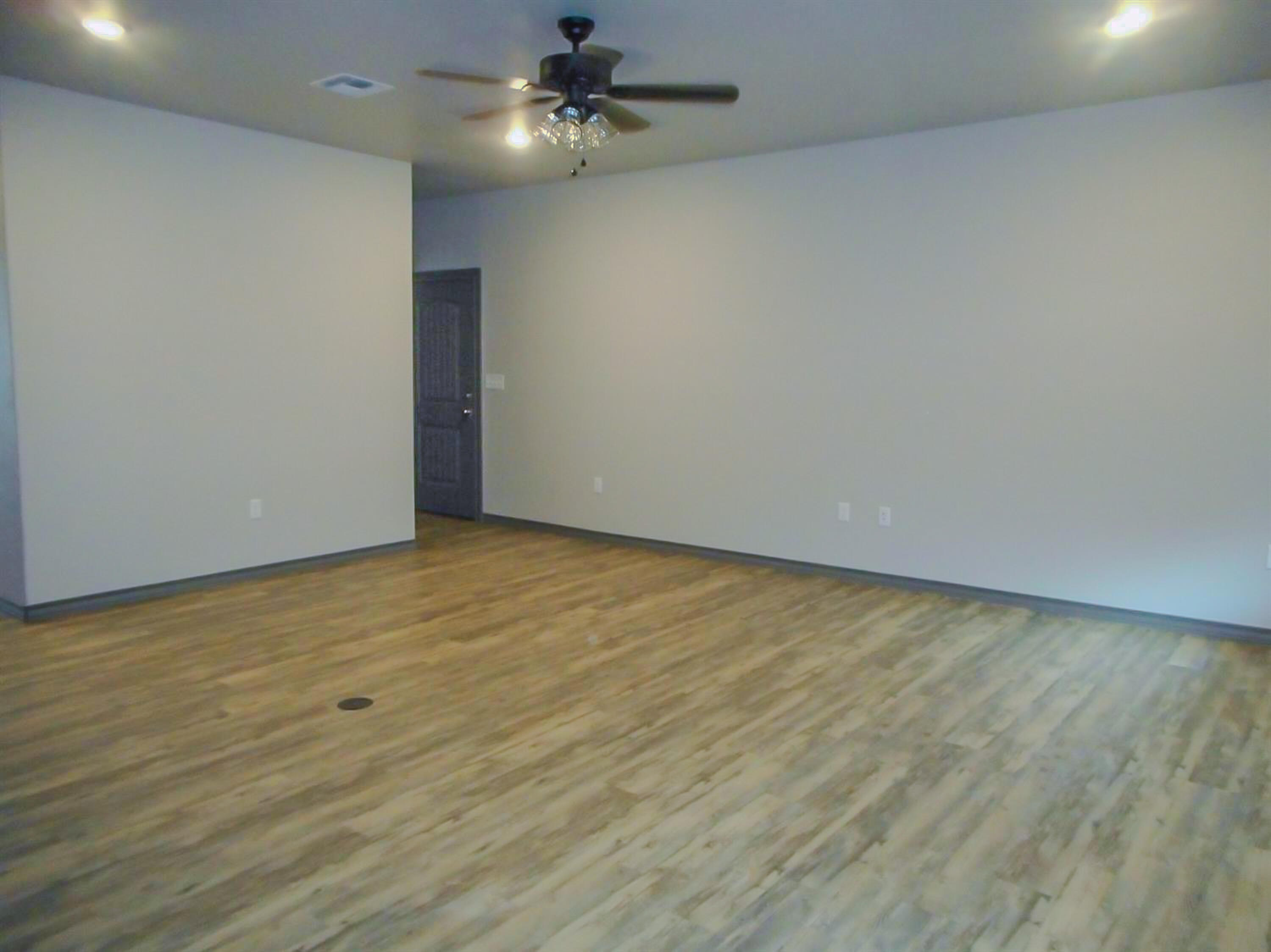 2026 102nd Street Lubbock, TX 79423 - Photo 9 of 16 an empty room with a ceiling fan and wooden floor