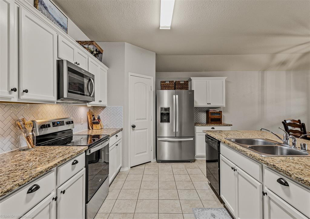 2440 Willard Way Forney, TX 75126 - Photo 12 of 25 a kitchen with stainless steel appliances granite countertop a refrigerator stove and sink